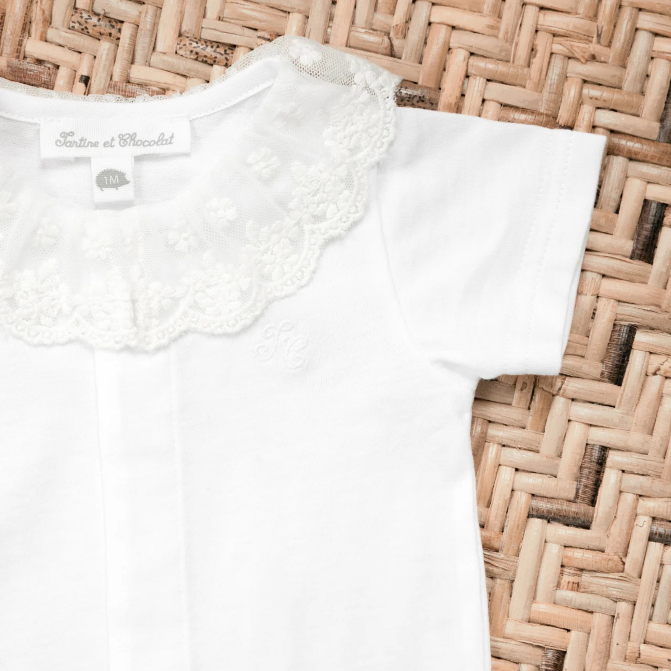 White baby jumpsuit with ruffle collar